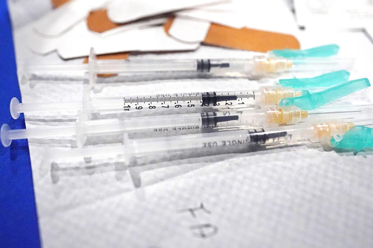 A closeup of syringes and a pile of Band-Aids.