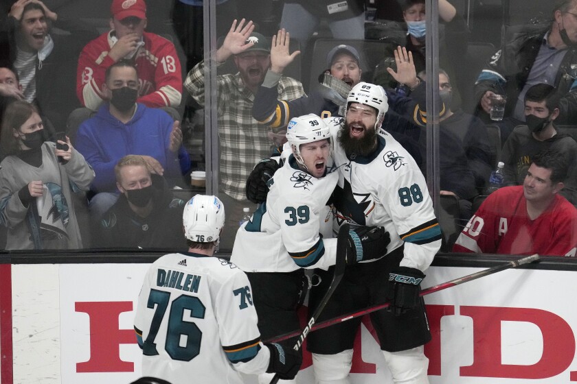 San Jose Sharks center Logan Couture (39) celebrates his with Brent Burns (88) and Jonathan Dahlen (76) after scoring a goal during overtime against the Detroit Red Wings of an NHL hockey game Tuesday, Jan. 11, 2022, in San Jose, Calif. The Sharks won 3-2 in overtime. (AP Photo/Tony Avelar)