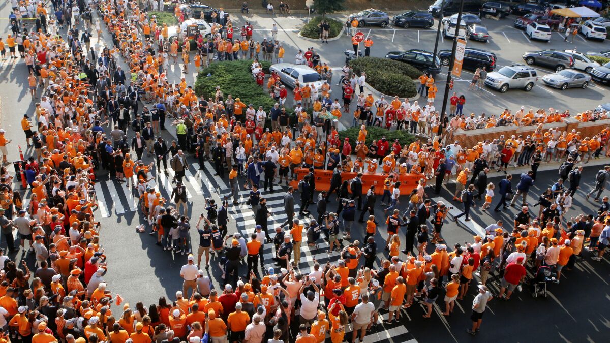FILE - In this Oct. 5, 2019, file photo, Tennessee players and coaches take part in the Vol Walk at Neyland Stadium before the team's NCAA college football game against Georgia in Knoxville, Tenn. Pre-game traditions are making a return this season, like Tennessee's pre-game Vol Walk, minus the high-fives or any other physical contact with players. No masks will be required--just encouraged--inside Neyland Stadium, the nation's fifth-largest stadium. (C.B. Schmelter/Chattanooga Times Free Press via AP, File)