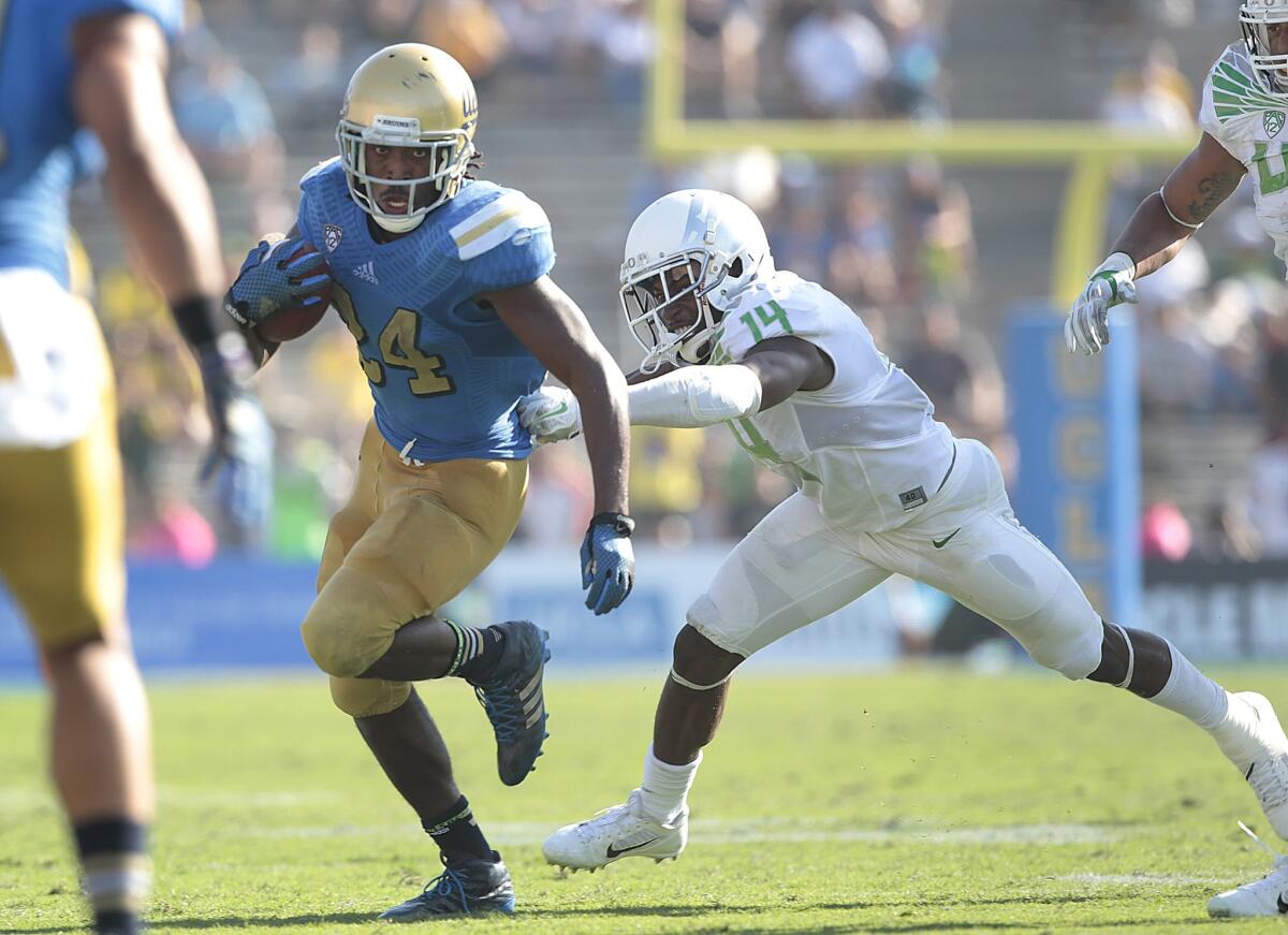 UCLA running back Paul Perkins sprints past Oregon defensive back Ifo Ekpre-Olomu in the second half.