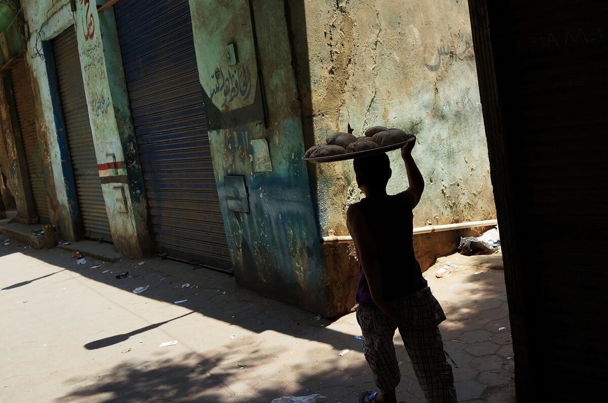 A boy carries bread through a working-class neighborhood of Cairo.