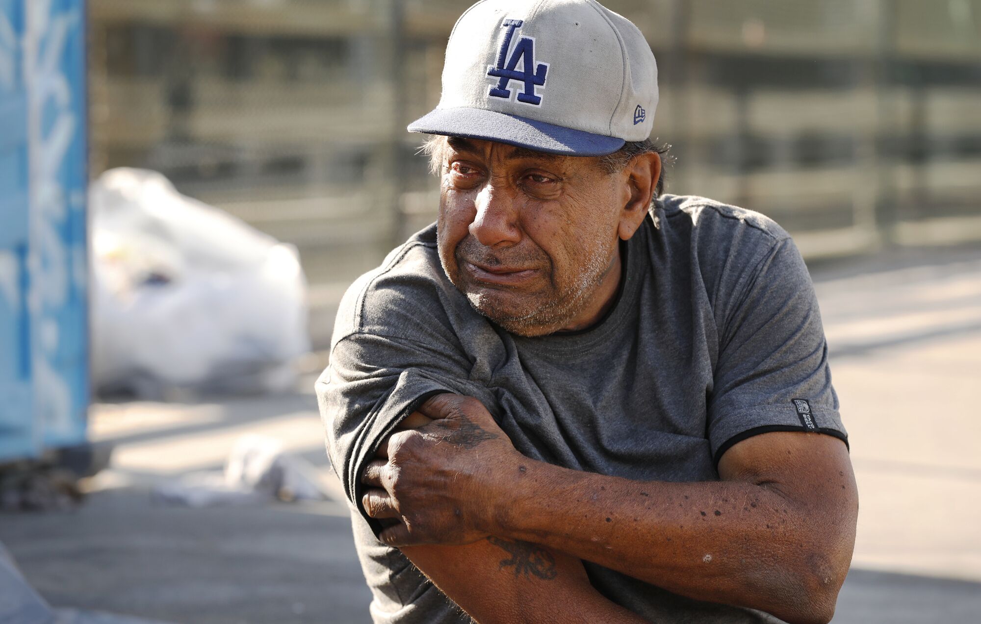 Eric Davido, who previously stayed in the El Puente shelter, sits outside his tent on a bridge over the 101 Freeway.
