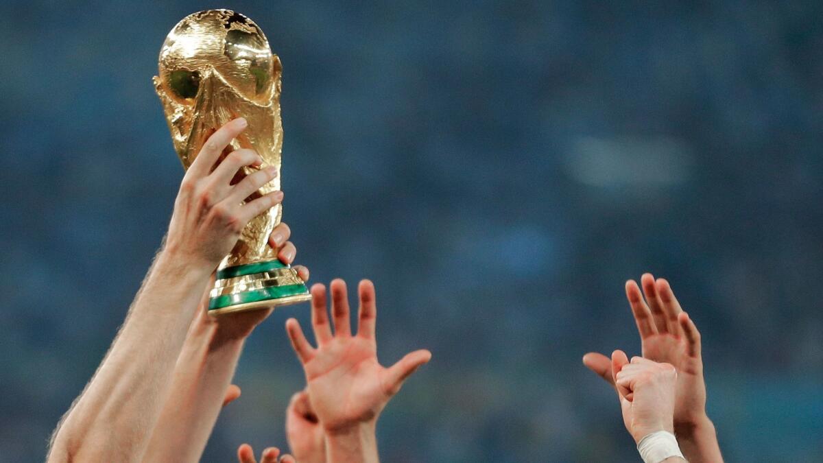 Players from Germany reach out to touch the World Cup trophy after defeating Argentina in Rio de Janeiro on July 13, 2014.