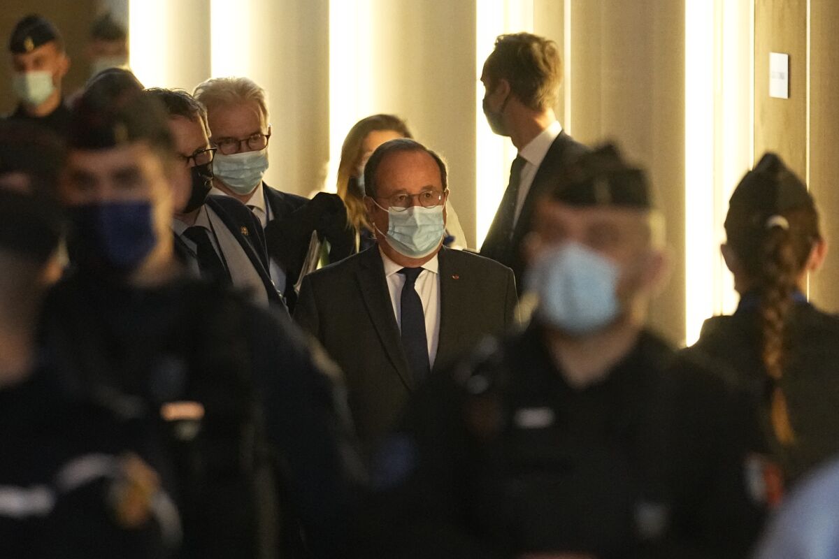 Former French President Francois Hollande, center, arrives at the special courtroom to testify in the Nov.2015 attacks trial, Wednesday, Nov. 10, 2021 in Paris. Hollande was at France's national stadium when a suicide bomber blew himself up outside the gates on Nov. 13, 2015, the first in a series of attacks that would last three more hours across Paris. Gunmen struck cafes and bars in the city center, and the night culminated with a bloody siege at the Bataclan concert hall. In all 130 people died in the attacks. Hollande ordered the final assault on the three remaining attackers inside the Bataclan. (AP Photo/Michel Euler)