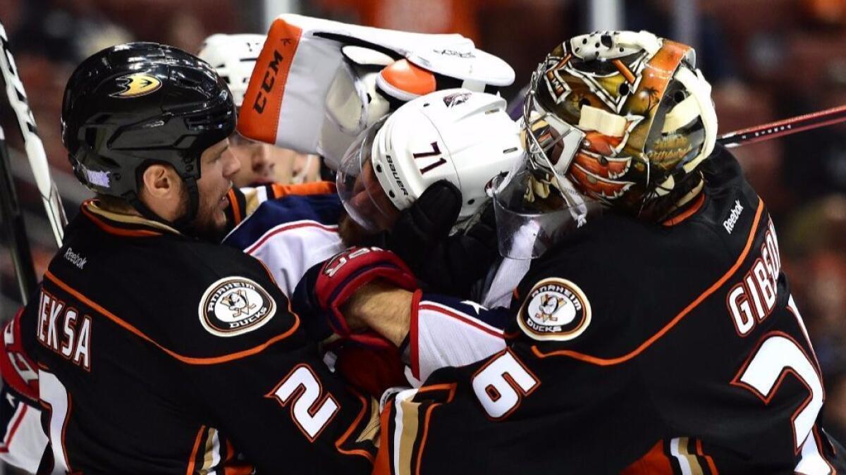 Blue Jackets forward Nick Foligno (71) is roughed up by Ducks defenseman Kevin Bieksa, left, and goalie John Gibson during the second period of a game at Honda Center on Oct. 28.