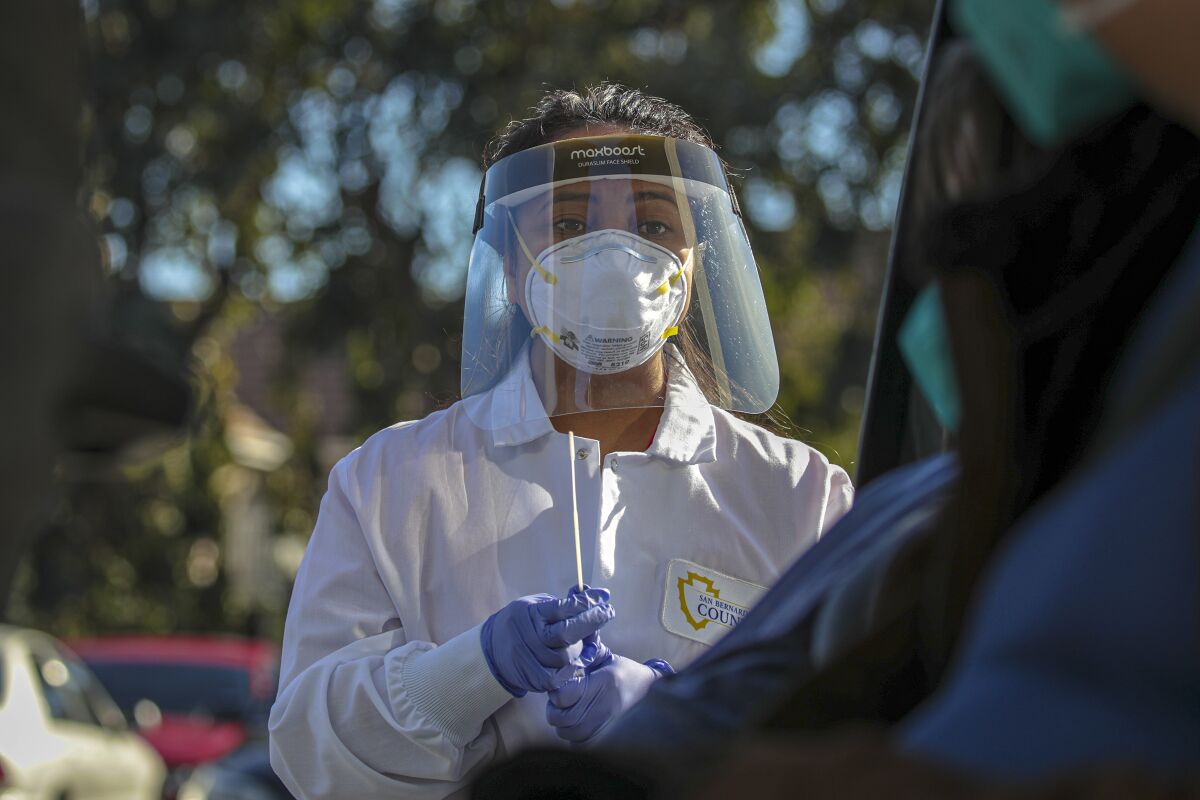 San Bernardino County Public Health Department nurse Marijorie Tabago collects a nasal sample to test for COVID-19.