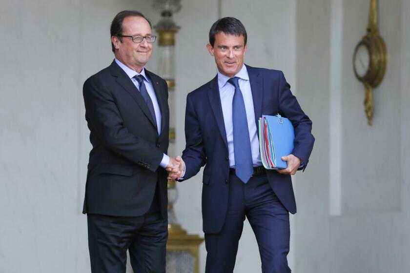 French President Francois Hollande and Prime Minister Manuel Valls shake hands at the Elysee Palace in Paris on Aug. 20.