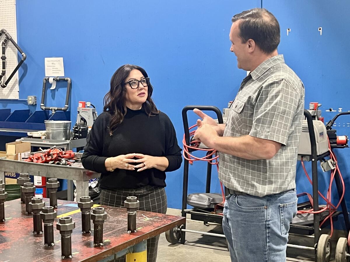 Oregon Rep. Lori Chavez-DeRemer speaks to a man on the floor of a manufacturing plant