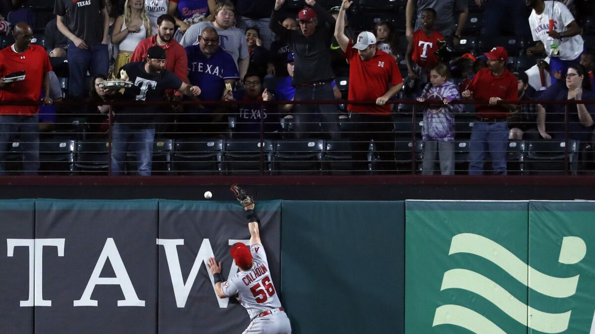 Fans look on as a ball that bounced off Angels right fielder Kole Calhoun's glove falls over the fence for a two-run homer for the Rangers' Asdrubal Cabrera on Tuesday night.