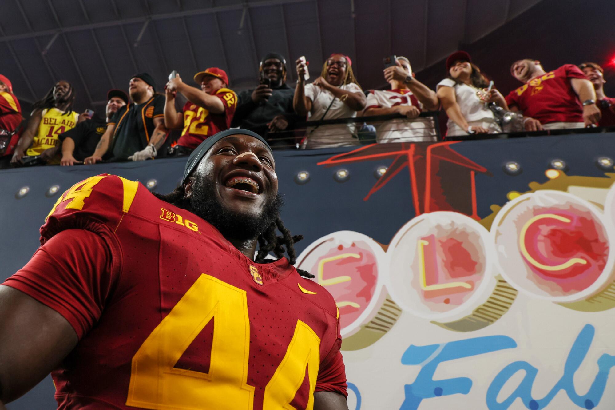 USC defensive end Sam Greene celebrates with family in the stands after the Trojans' win Sunday.