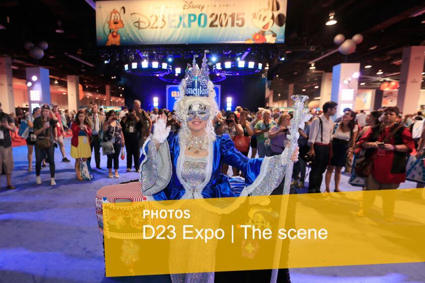 Disney fans surround and photograph a contestant wearing a Disneyland 60th Diamond Jubilee anniversary costume during the Mousequerade.