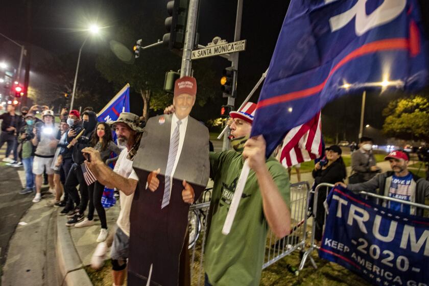 BEVERLY HILLS, CA - NOVEMBER 03: Trump supporters wave flags and cheer as they gather on Santa Monica Blvd. at Beverly Dr. on Tuesday, Nov. 3, 2020 in Beverly Hills, CA. (Brian van der Brug / Los Angeles Times)
