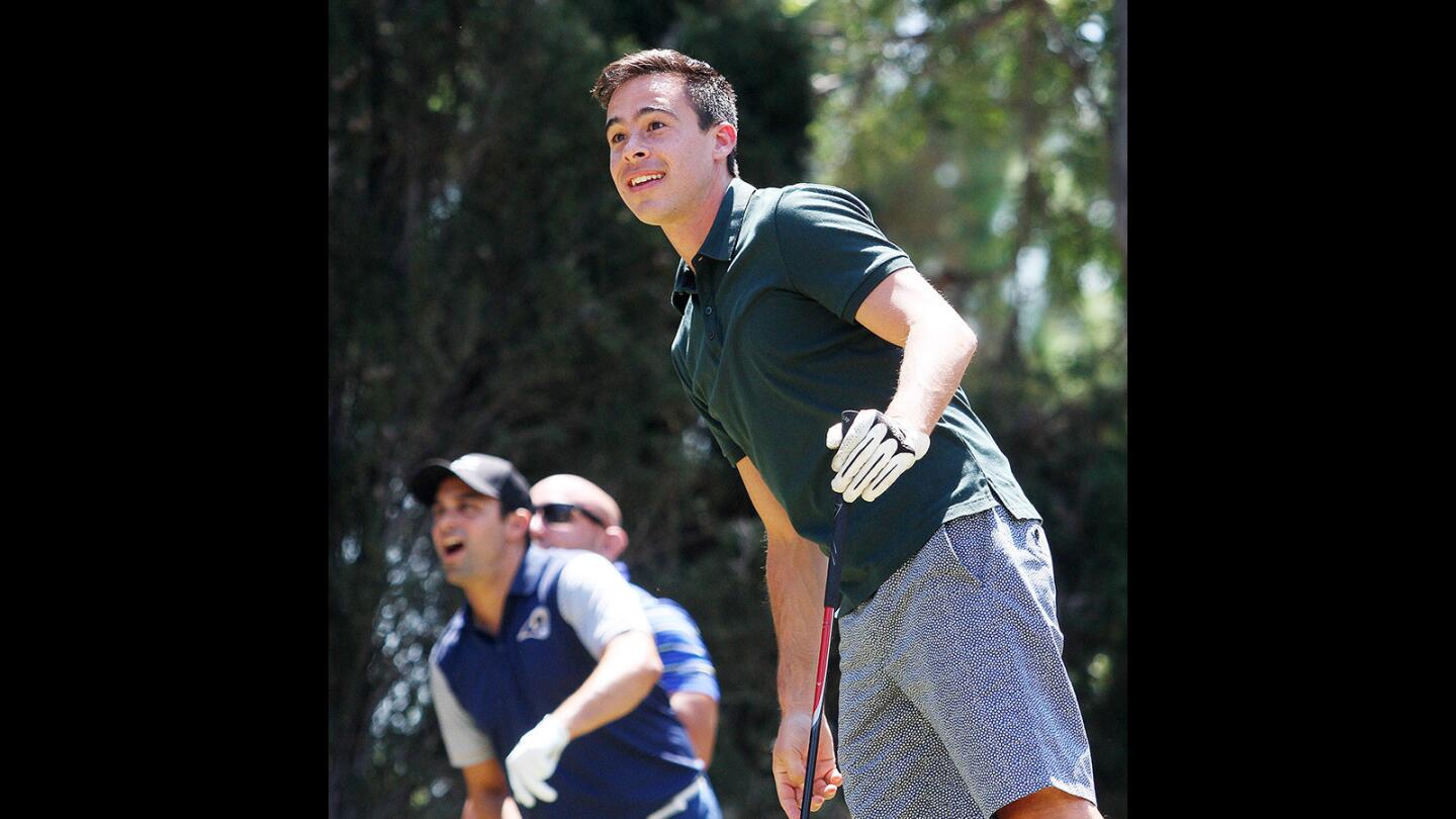 Chamber president Rion Zimmerman leans into his tee shot trying to coax it out of the fairway bunker he landed in with his friends and teammates watching at the 33rd Annual Crescenta Cañada Golf Classic at the La Cañada Flintridge Country Club on Monday, August 22, 2016.