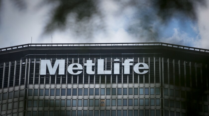 FILE - This July 5, 2013 file photo shows The Metlife building sign in New York. MetLife is selling its home and auto insurance business to Farmers Group for $3.94 billion, the insurers said Friday, Dec. 11, 2020. (AP Photo/Bebeto Matthews, File)