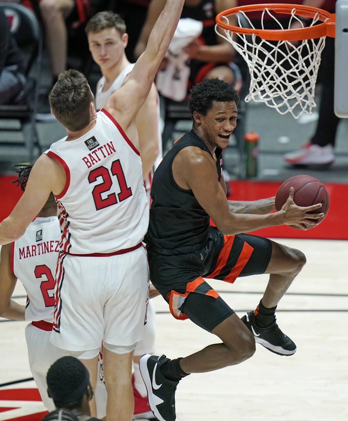 Oregon State guard Gianni Hunt, right, goes to the basket as Utah forward Riley Battin (21) defends during the second half during an NCAA college basketball game Wednesday, March 3, 2021, in Salt Lake City. (AP Photo/Rick Bowmer)
