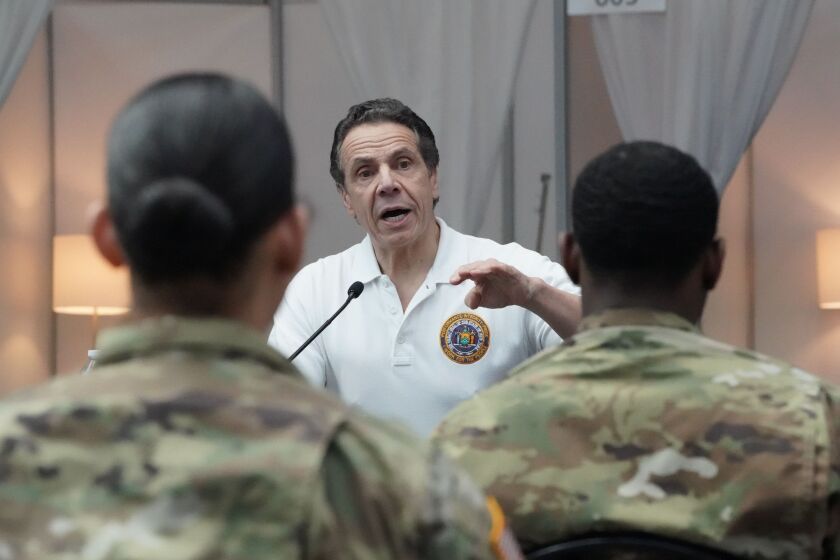 National Guard troops listen as New York Governor Andrew Cuomo speaks to the press at the Jacob K. Javits Convention Center in New York, on March 27, 2020. - The New York National Guard, the US Army Corps of Engineers, and Javits employees are constructing a 1,000-bed facility at the center, as the state tries to contain the rising coronavirus cases. (Photo by Bryan R. Smith / AFP) (Photo by BRYAN R. SMITH/AFP via Getty Images)