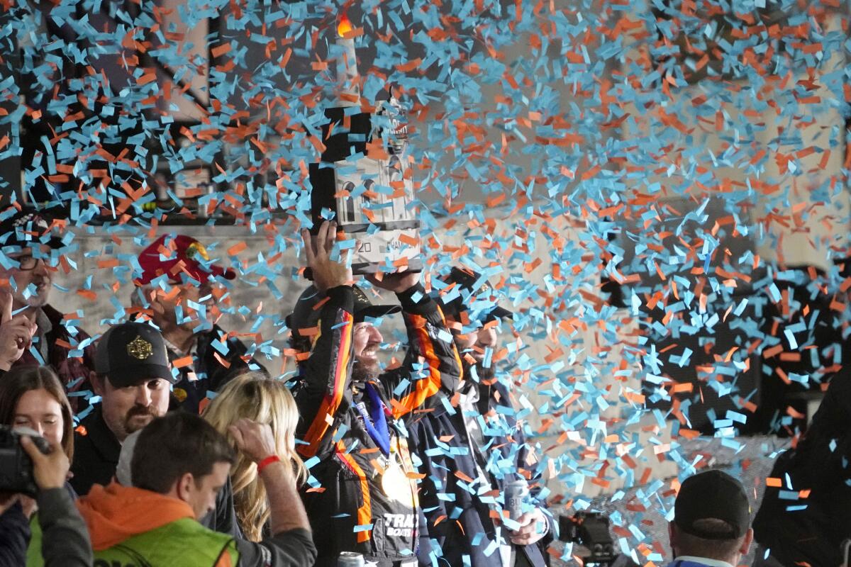 NASCAR Cup Series driver Martin Truex Jr. life his trophy after winning the Busch Light Clash NASCAR exhibition auto race at Los Angeles Memorial Coliseum Sunday, Feb. 5, 2023, in Los Angeles. (AP Photo/Mark J. Terrill)