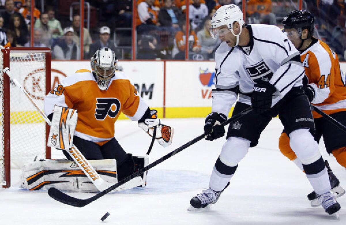Kings forward Jeff Carter, center, tries to settle the puck in front of Philadelphia Flyers goalie Ray Emery and defenseman Kimmo Timonen, right, during the first period of the Kings' 3-2 road win Monday.