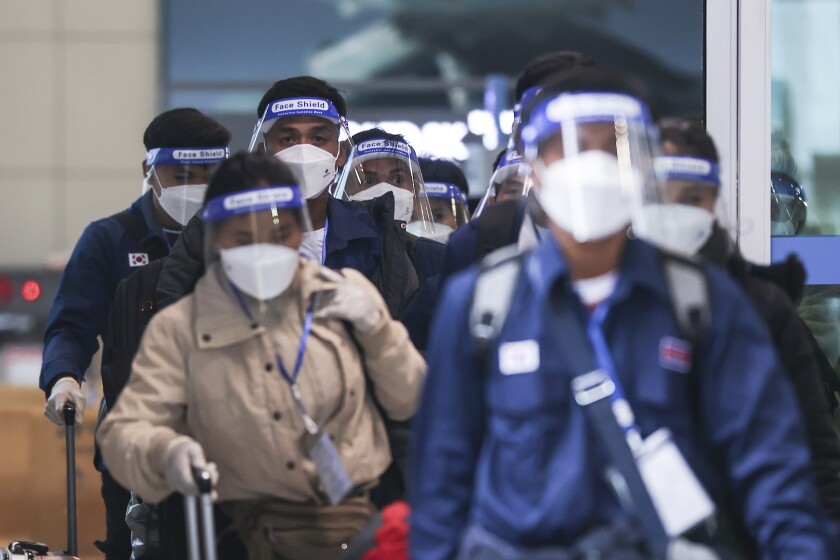Pasajeros utilizan mascarillas y caretas debido a la pandemia del coronavirus, el lunes 30 de noviembre de 2021, a su llegada al Aeropuerto Internacional Incheon, de Corea del Sur. (Lim Hwa-young/Yonhap via AP, Archivo)
