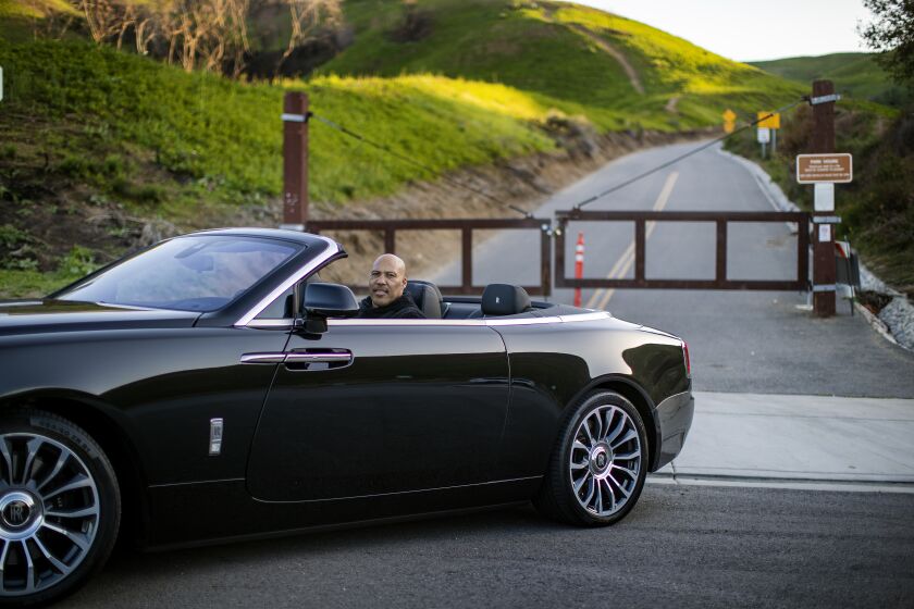 CHINO HILLS, CA - MARCH 16, 2021: LaVar Ball sits in his Rolls Royce in front of a trail where he use to train his sons in their early years at Chino Hills State Park on March 16, 2021 in Chino Hills, California. The basketball playing Ball brothers Lonzo, LiAngelo and LaMelo are all expected to play in the NBA this year and put Chino Hills on the map for the rest of the nation.(Gina Ferazzi / Los Angeles Times)