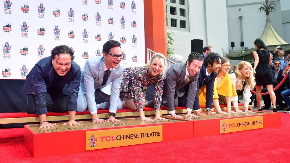 The cast from "The Big Bang Theory" — Johnny Galecki, left, Jim Parsons, Kaley Cuoco, Simon Helberg, Kunal Nayyar, Mayim Bialik and Melissa Rauch — place their hands into two blocks of cement at a handprint ceremony at the TCL Chinese Theater in Hollywood, California.