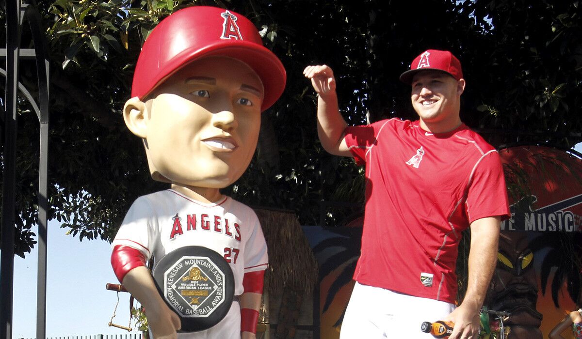 Los Angeles Angels' Mike Trout smiles after unveiling a life-sized bobblehead doll before a baseball game against the Texas Rangers on Friday.