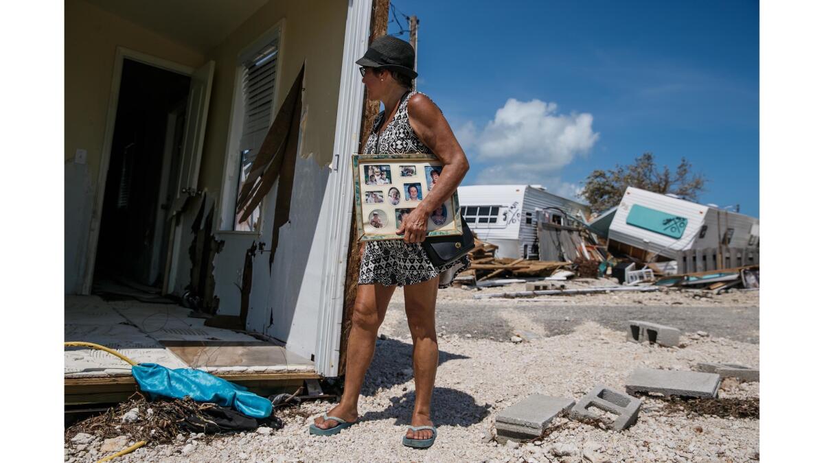 Laura Costello peers into her home that was ripped apart by Hurricane Irma, at the Sea Breeze trailer park in Islamorada.