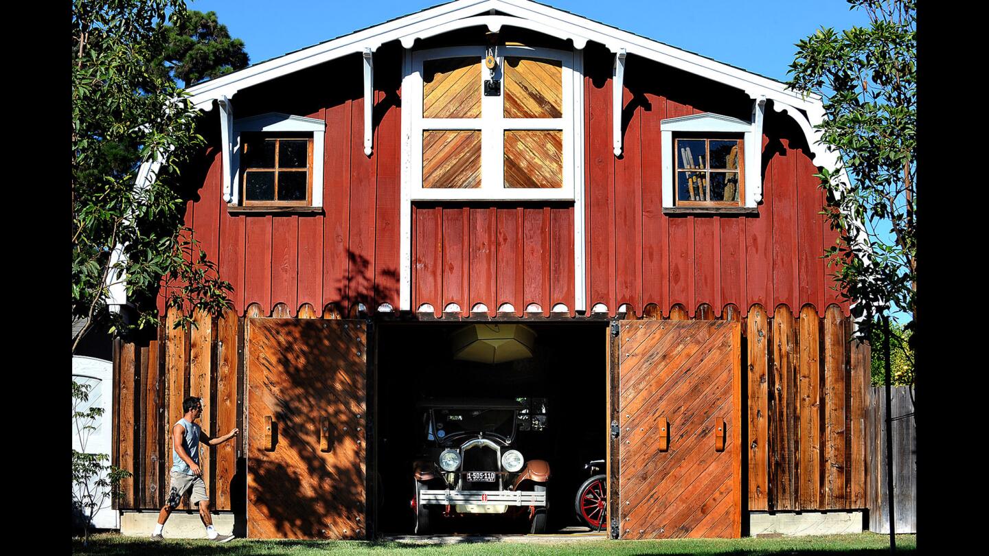 Dennis Holland Jr. walks past his father's barn in Newport Beach. His dad died of cancer last spring and left behind a lifetime of unfinished side projects.