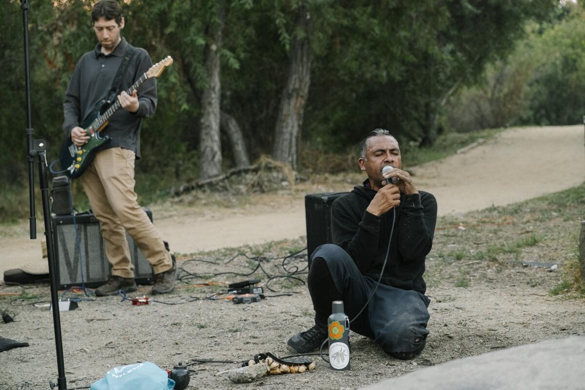 Frontman Antonio Sanchez on his knees while Jason Suddith plays guitar behind him 