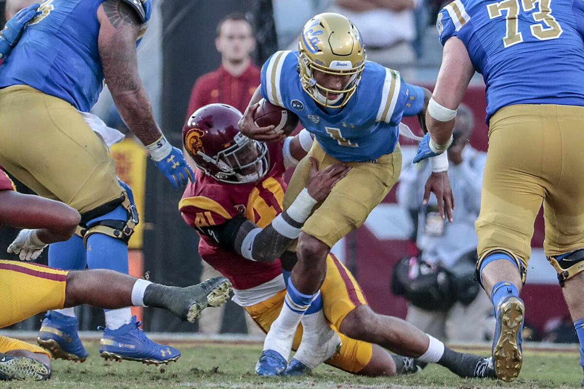 UCLA quarterback Dorian Thompson-Robinson avoids getting tackled by USC linebacker Juliano Falaniko 