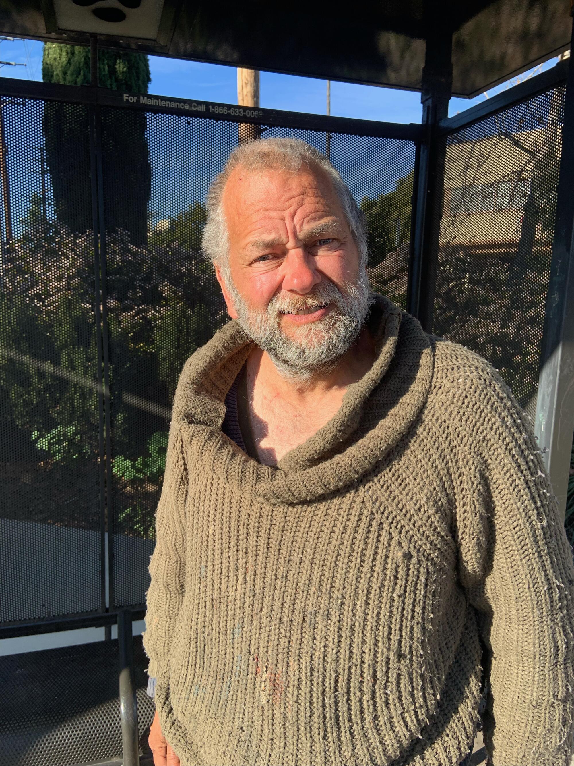 Bearded man in a sweater standing outside