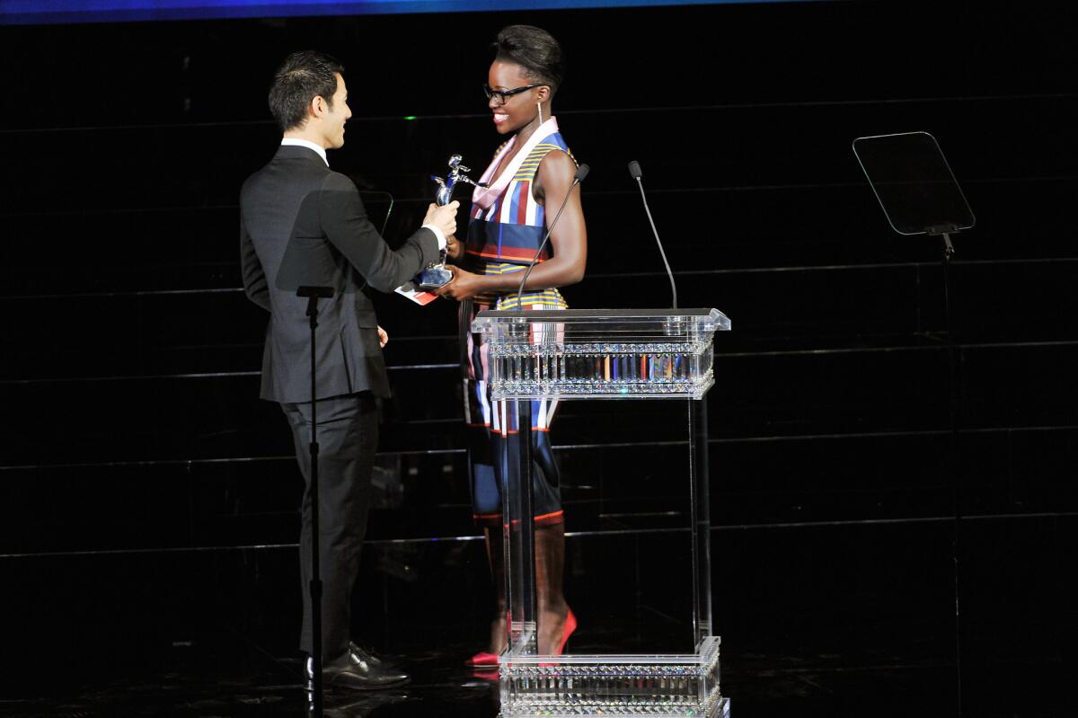 Fashion designer Joseph Altuzarra, left, is presented with the CFDA Fashion Award for Womeswear by actress Lupita Nyong'o at Alice Tully Hall, Lincoln Center in New York City.