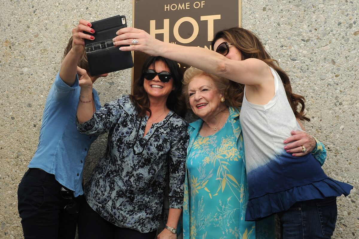 Betty White poses for a selfie on the studio lot with her "Hot in Cleveland" costars
