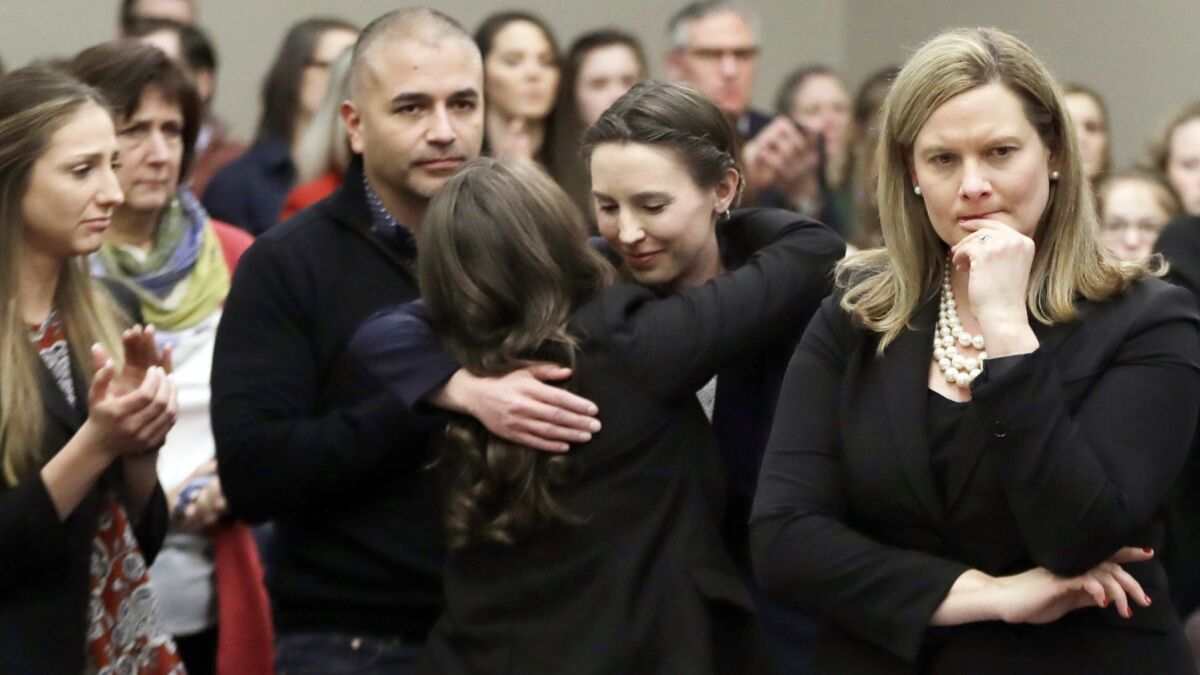 Former gymnast Rachael Denhollander, center, is hugged after giving her victim impact statement during the seventh day of Larry Nassar's sentencing hearing on Jan. 24, 2018.