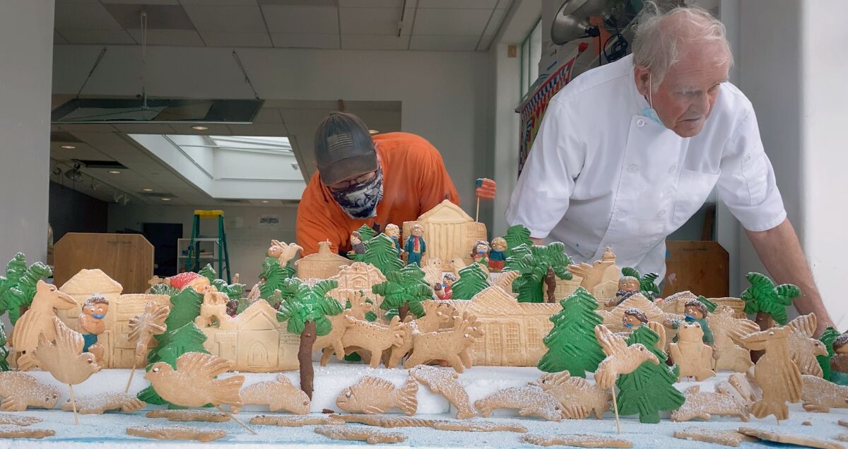 Francois Goedhuys assembles the cookie village for the Athenaeum.