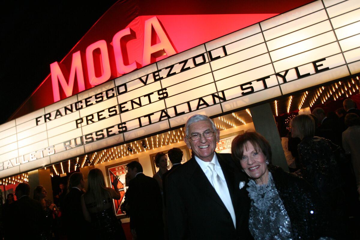 Eli Broad and wife Edythe stand in front of a lighted MOCA marquee.
