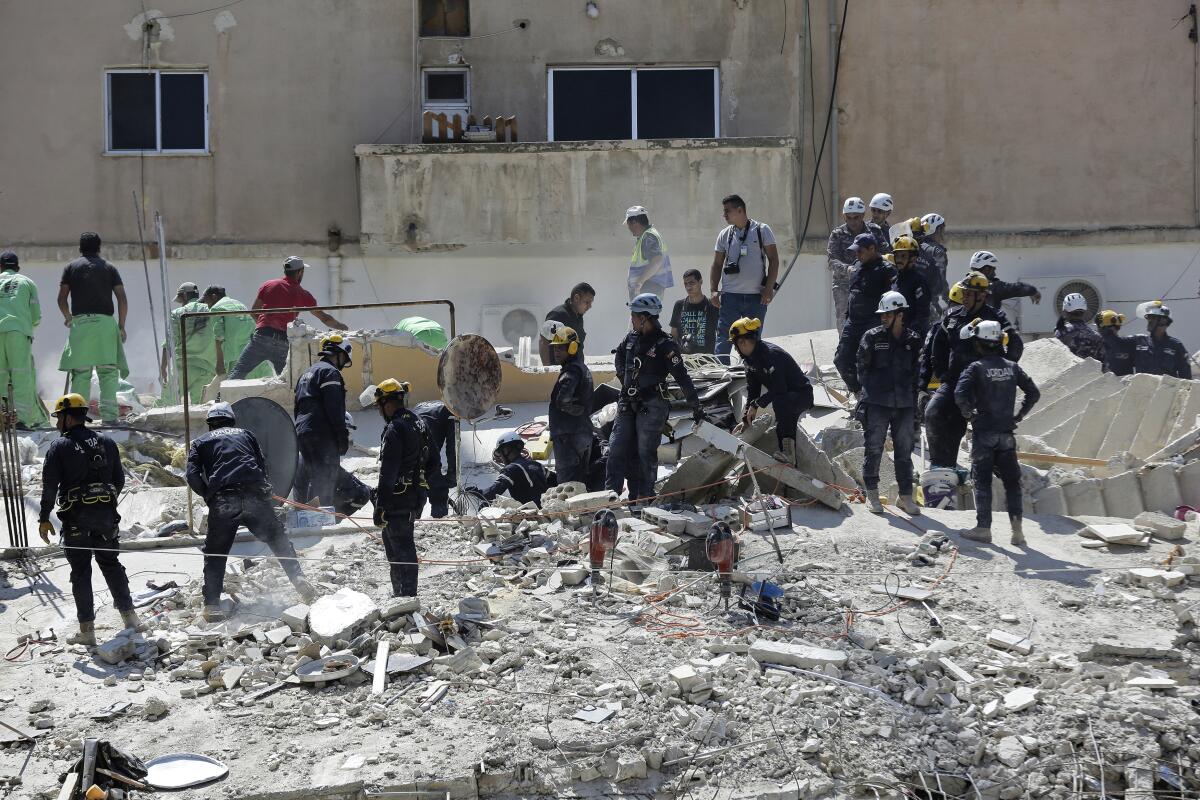 FILE - Jordanian Civil Defense rescue teams conduct a search operation for residents of a four-story residential building that collapsed on Tuesday, killing several people and wounding others, in the Jordanian capital of Amman, Wednesday Sept. 14, 2022. On Thursday, Jordanian rescue teams pulled another body from the rubble of the collapsed building, bringing the death toll from the incident to at least 10. Ten people were wounded. It remained unclear what caused the collapse. (AP Photo/Raad Adayleh, File)