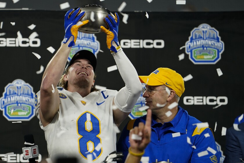 Pittsburgh quarterback Kenny Pickett and head coach Pat Narduzzi celebrate with the trophy after their win against Wake Forest in the Atlantic Coast Conference championship NCAA college football game Saturday, Dec. 4, 2021, in Charlotte, N.C. (AP Photo/Jacob Kupferman)
