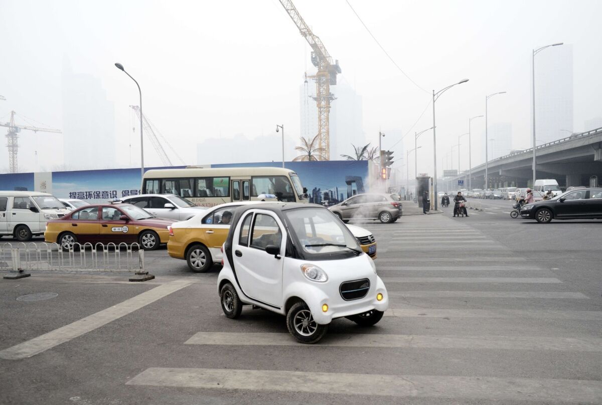 An electric car is driven through Beijing on Dec. 8, 2015.