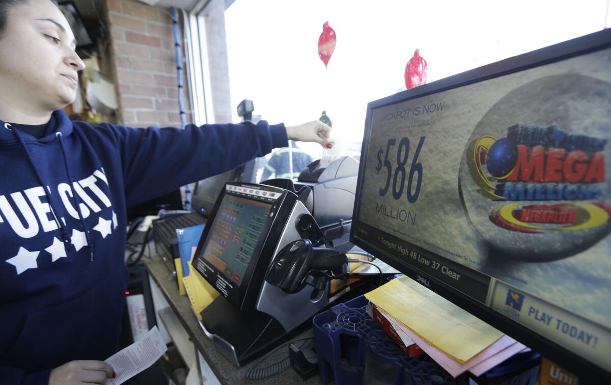 Karen Rodriguez prints out a Mega Millions lottery ticket at a convenience store Monday in Dallas.