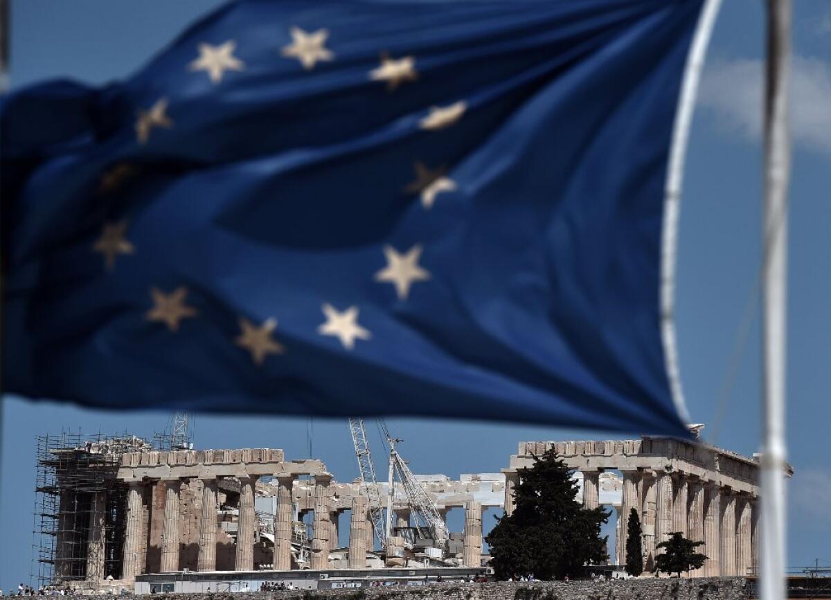 A European Union flag waves near the Parthenon atop the Acropolis hill in Athens.