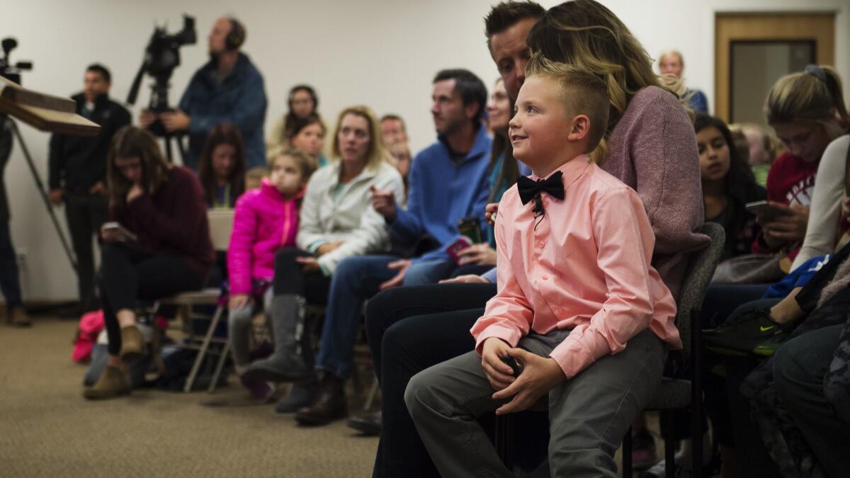 Third-grader Dane Best sits on his mother's lap before urging town leaders in Severance, Colo., to lift a ban on throwing snowballs.