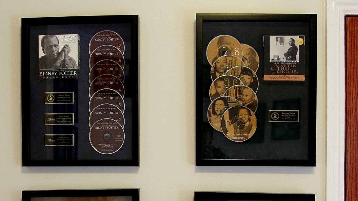 Two of Deyan Audio's Grammy-winning audiobooks hang on the wall.