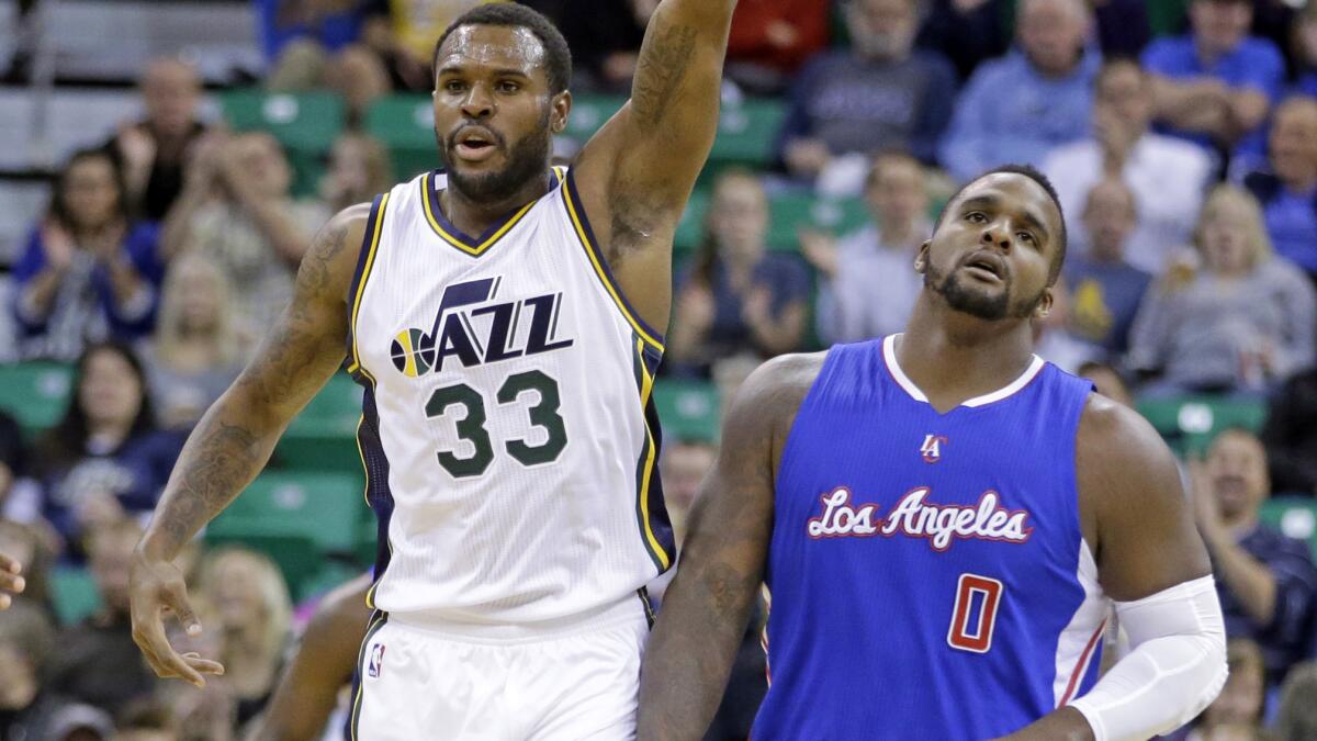 Utah Jazz forward Trevor Booker, left, celebrates after hitting a three-pointer as Clippers forward Glen Davis walks away during the Clippers' preseason loss Monday.