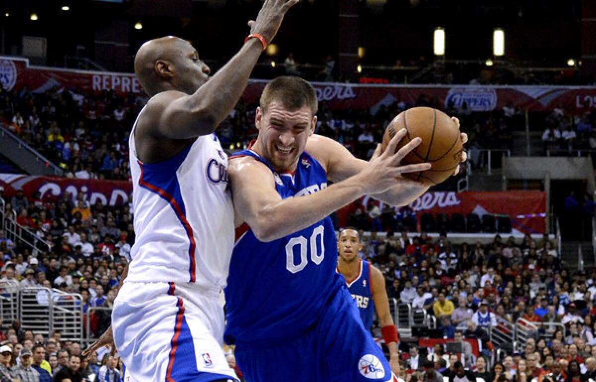 Clippers reserve big man Lamar Odom tries to cut off a drive by 76ers center Spencer Hawes in the first half Wednesday night at Staples Center.
