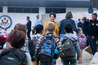 Laguna Beach school board president Carol Normandin, center, welcomes students back to school at El Morro Elementary on Monday, Aug. 22.