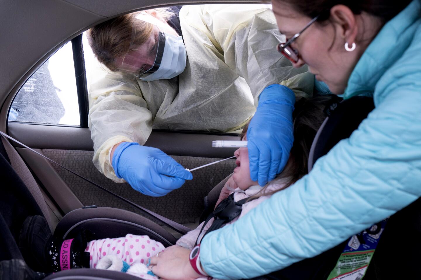 Canada: A medical professional collects a sample from a young girl at a drive-through coronavirus screening clinic in Montreal.