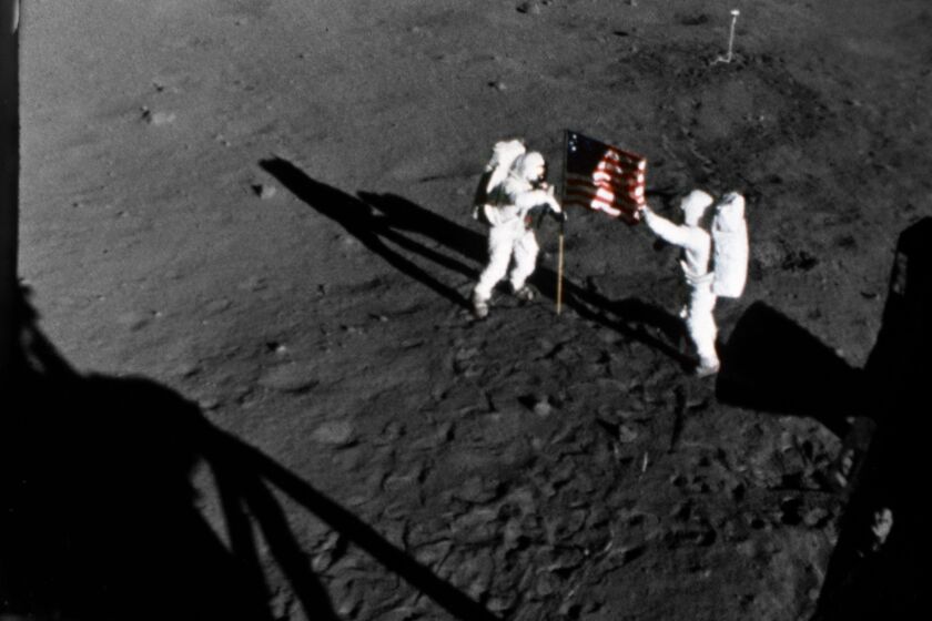 Astronauts Neil Armstrong, left, and Buzz Aldrin set up a U.S. flag on the moon July 20, 1969.