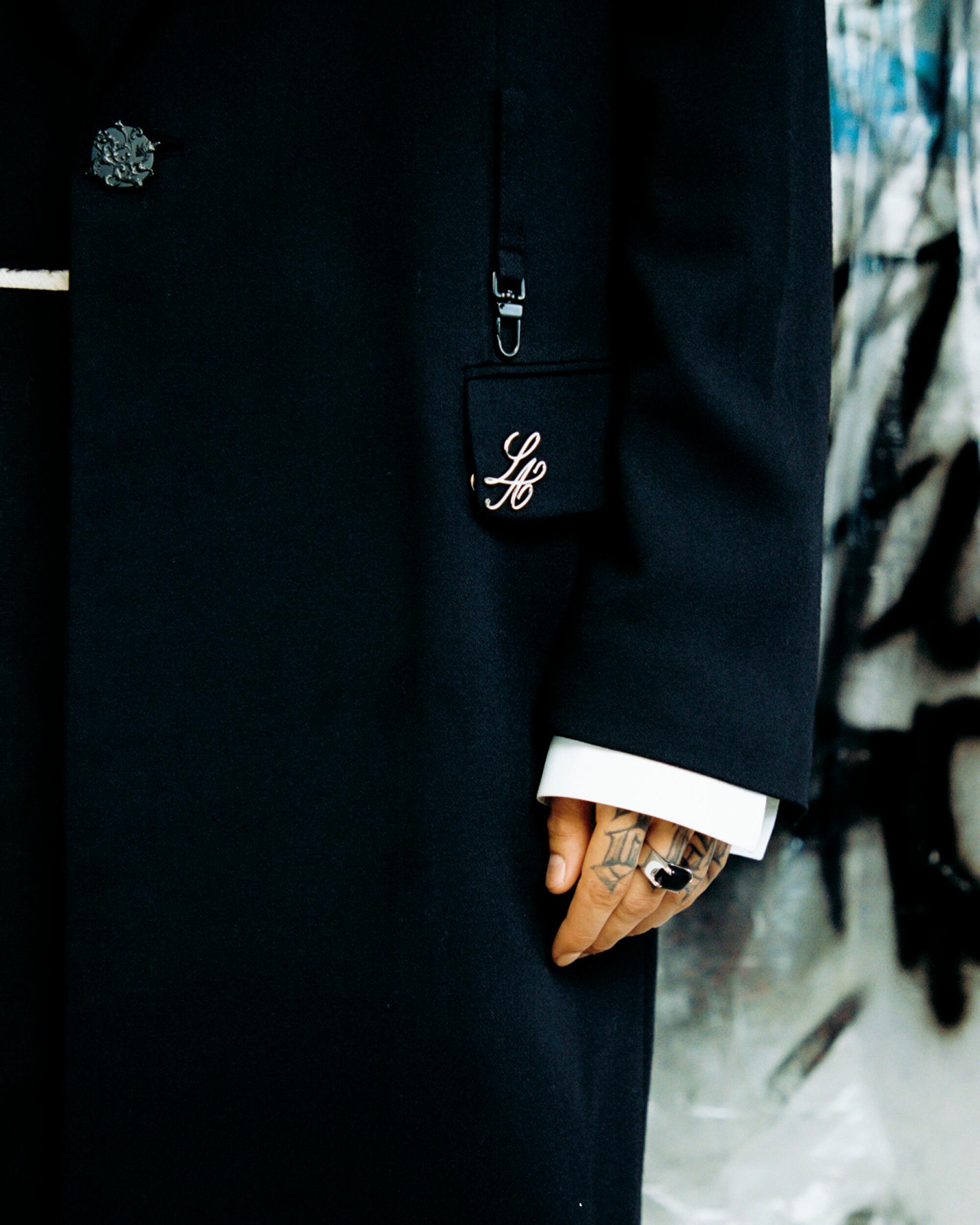 A closeup of a black suit sleeve with a white cuff peeking out.
