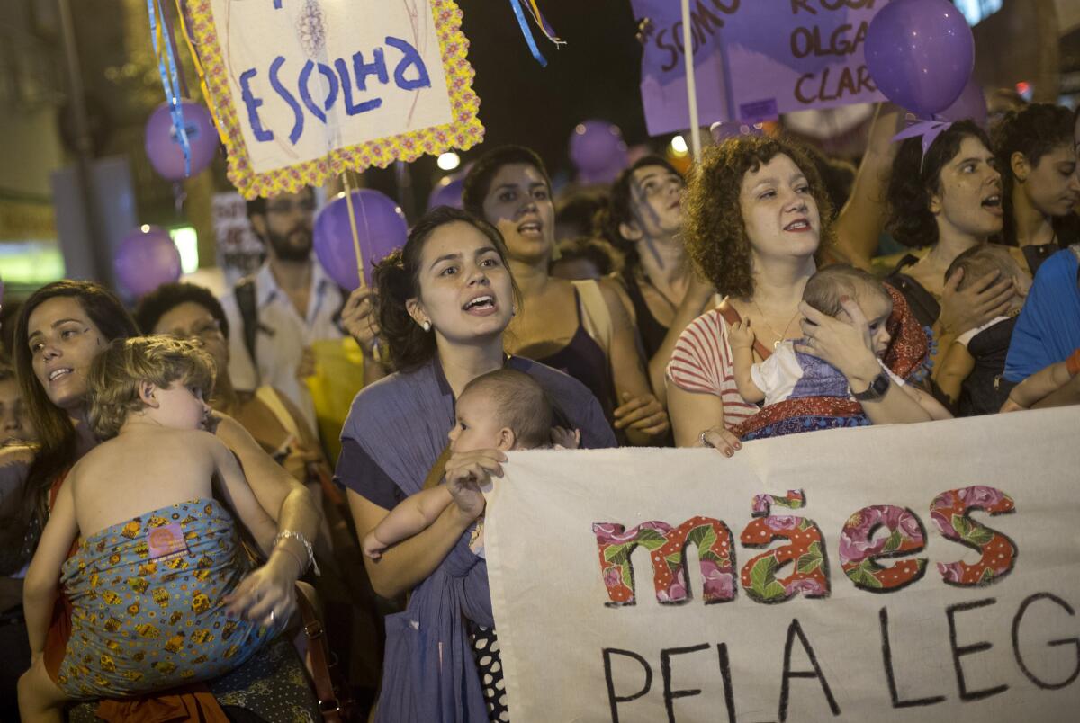 Mothers carry their children as they protest demanding the legalization of abortion during a demonstration to mark International Women's Day, in Rio de Janeiro, Brazil, on March 8, 2016.